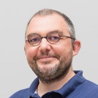 Jerome Gabalde - Managing Director France : homme souriant avec une barbe et des cheveux gris et courts ; petites lunettes rondes en corne