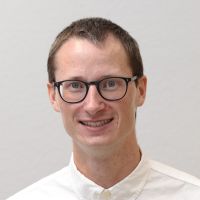 Victor Weitzmann - Sales Operations Manager: Smiling man with short, brown hair and square, black glasses
