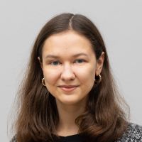 Anya Sizova - Business Development Assistant: Smiling woman with blue eyes and long, slightly wavy brown hair.