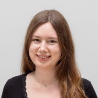 Melanie Adler - Business Development Assistant: Smiling woman with long brown hair and brown eyes