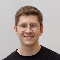 Valentin Schönrock - Consultant System Integration: Smiling man with short light brown hair and thin, golden, rounded glasses.