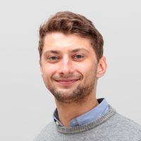 Tilmann Bornschein - Senior Sales Manager: Smiling man with a short dark bar and wavy auburn hair.